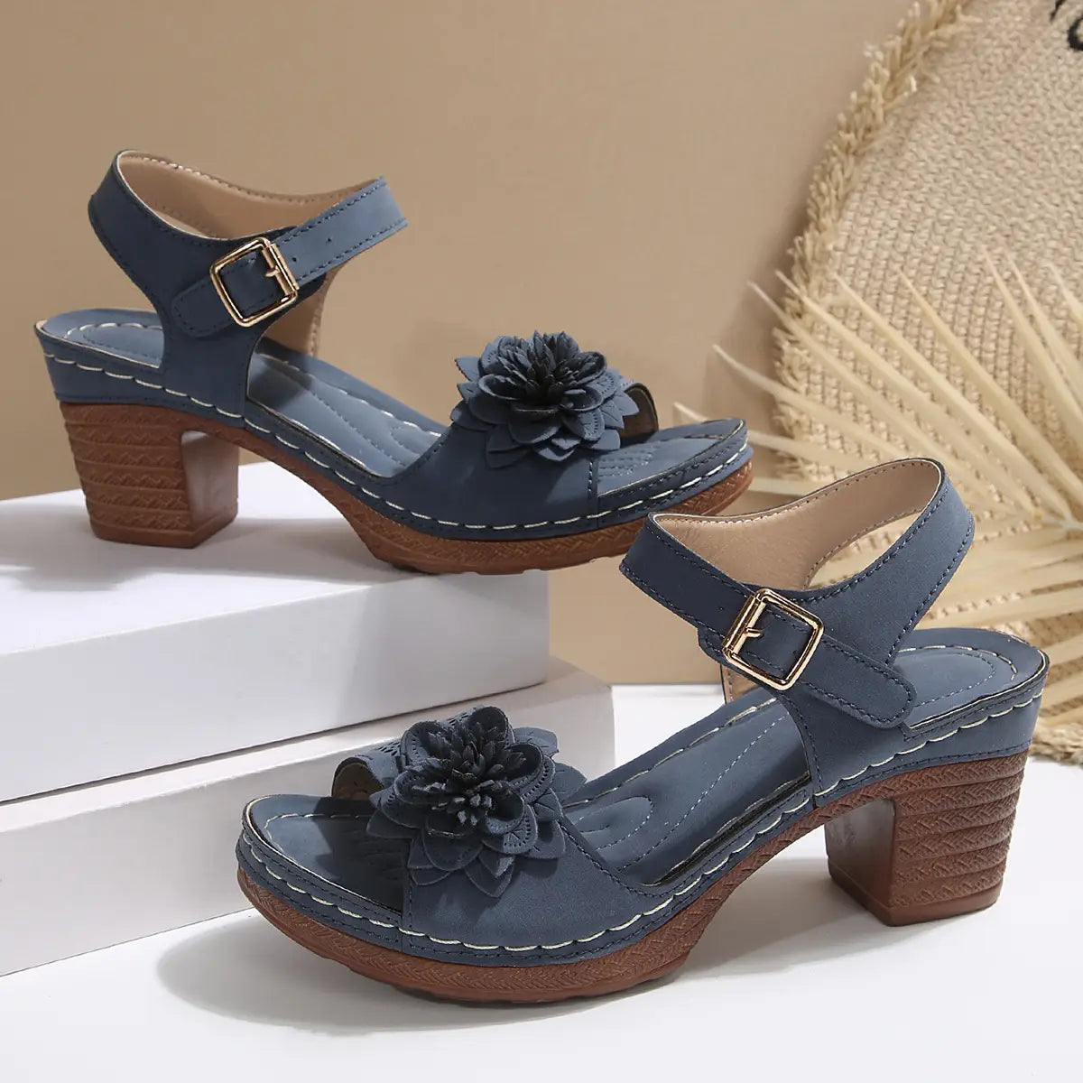 Beige floral flowers chunky heel sandals featuring blue leather with a textured wooden block heel and a decorative black fabric flower on the toe perfect for heel sandals summer.