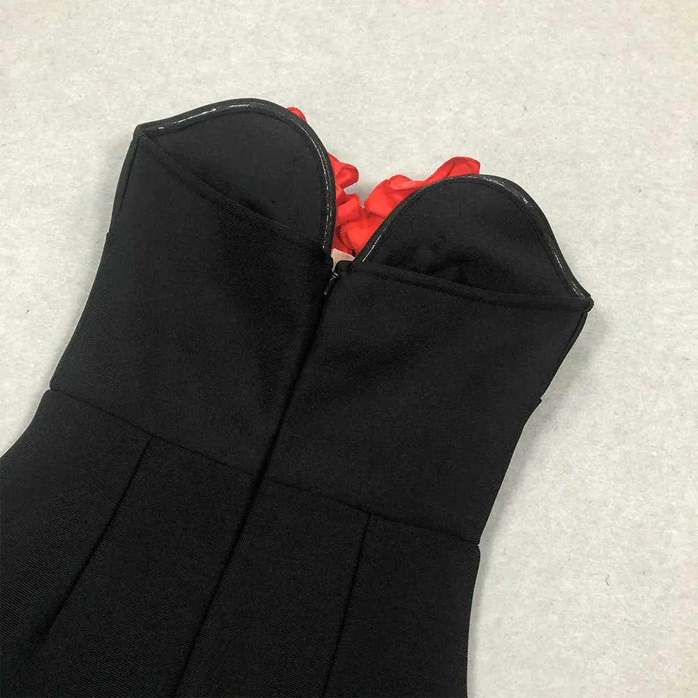 Black corset style top with a structured fitted design and contrasting red fabric peeking from the neckline in the white temperament socialite flower chain evening dress style temperament socialite collection.