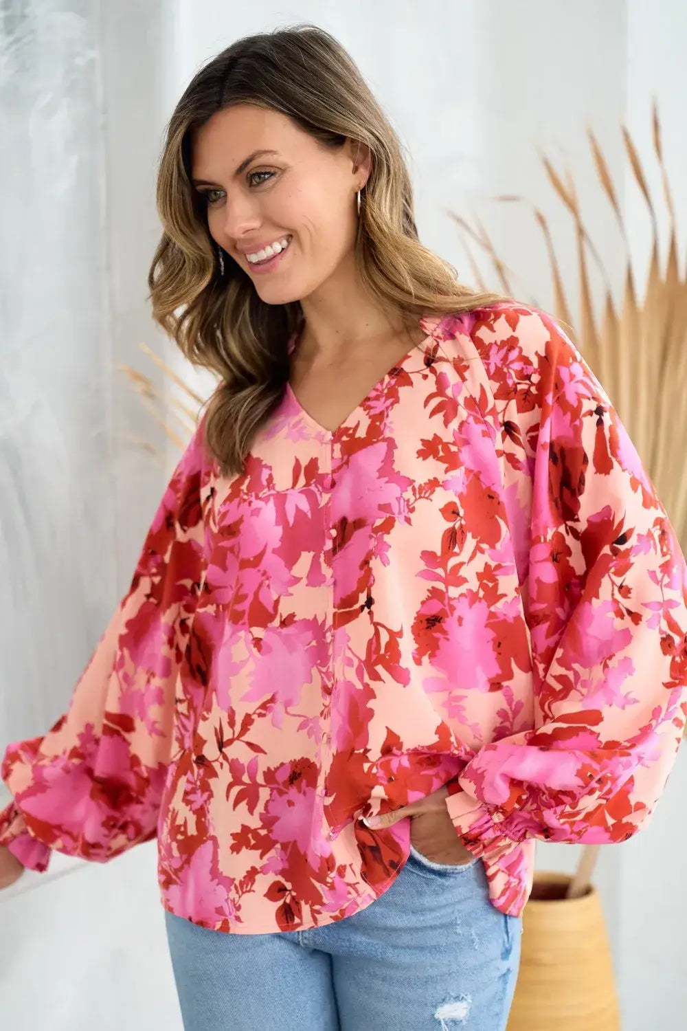 a vibrant pink and red decor button floral blouse featuring loose puffy sleeves and a lightweight fabric perfect for stylish casual wear