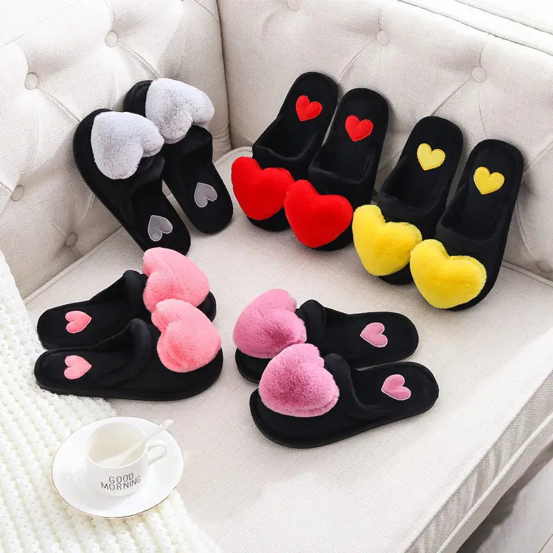 black plush home slippers with fluffy heart-shaped decorations in white red yellow and pink designed as cute love slippers for winter warmth
