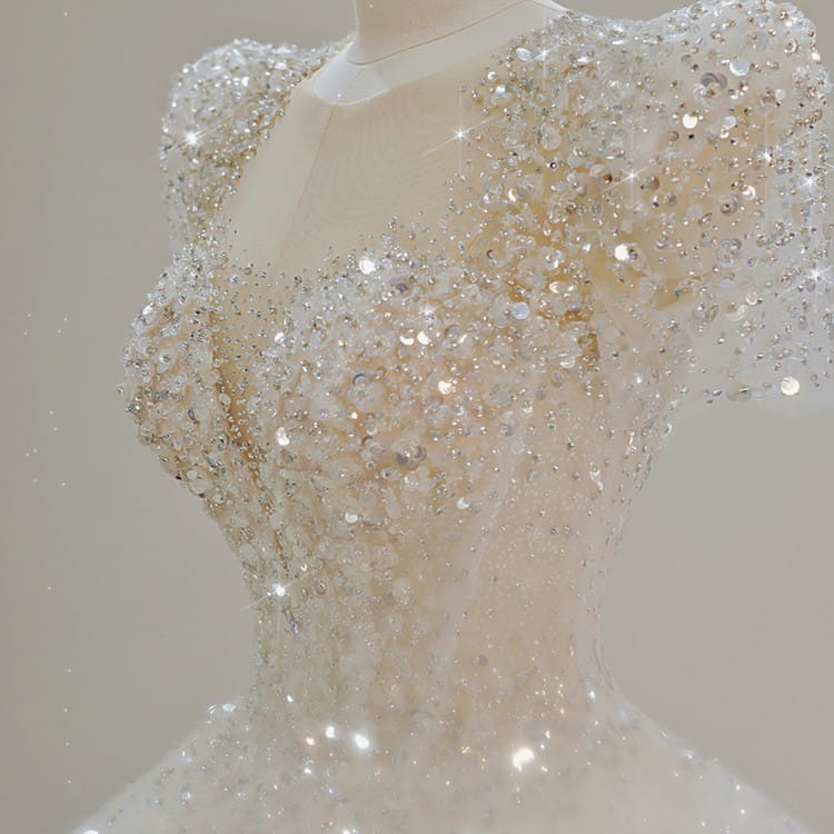 A sparkling white wedding dress with intricate silver and clear sequins, featuring puffy sleeves, a fitted bodice, and a voluminous tail ideal for a white floral wedding or floral wedding dress theme.