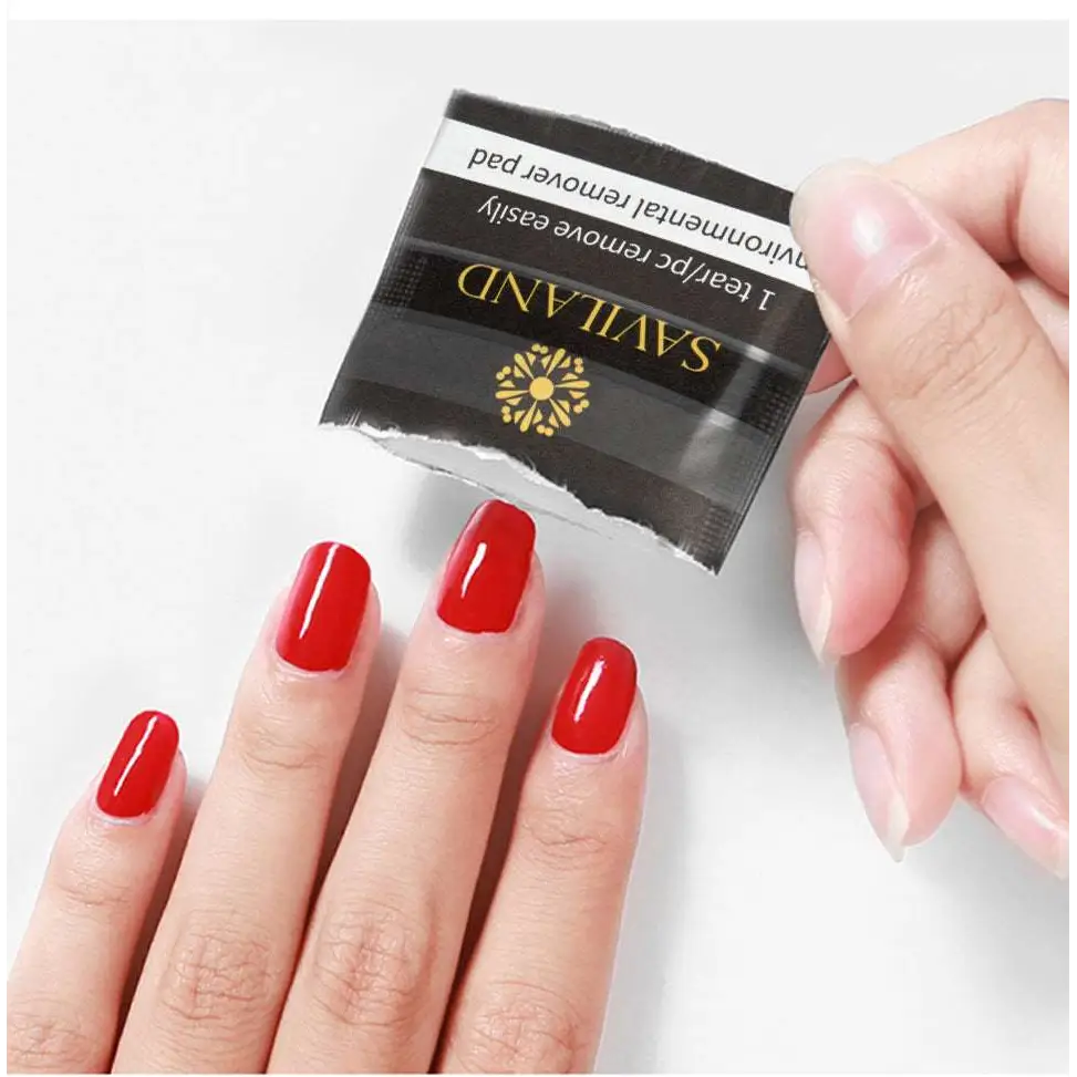 Black and gold packaged saviland nail polish remover 200pcs box held above red manicured nails for effective nail polish removal