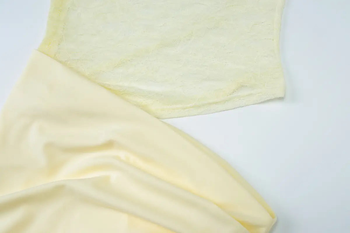 a soft pale yellow fabric with a smooth texture and subtle folds used in a burgundy satin y2k lace suspender dress