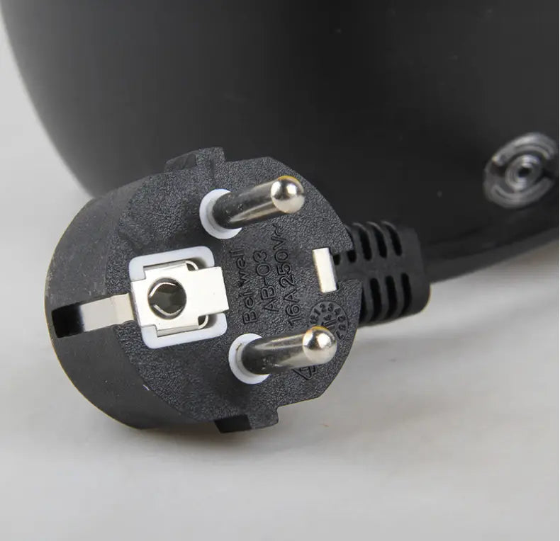 Black plastic European-style power plug with silver metal pins and grounding clip for yellow and black handheld steam cleaner with flexible nozzle suitable for color box packaging and luxury women’s fashion use.