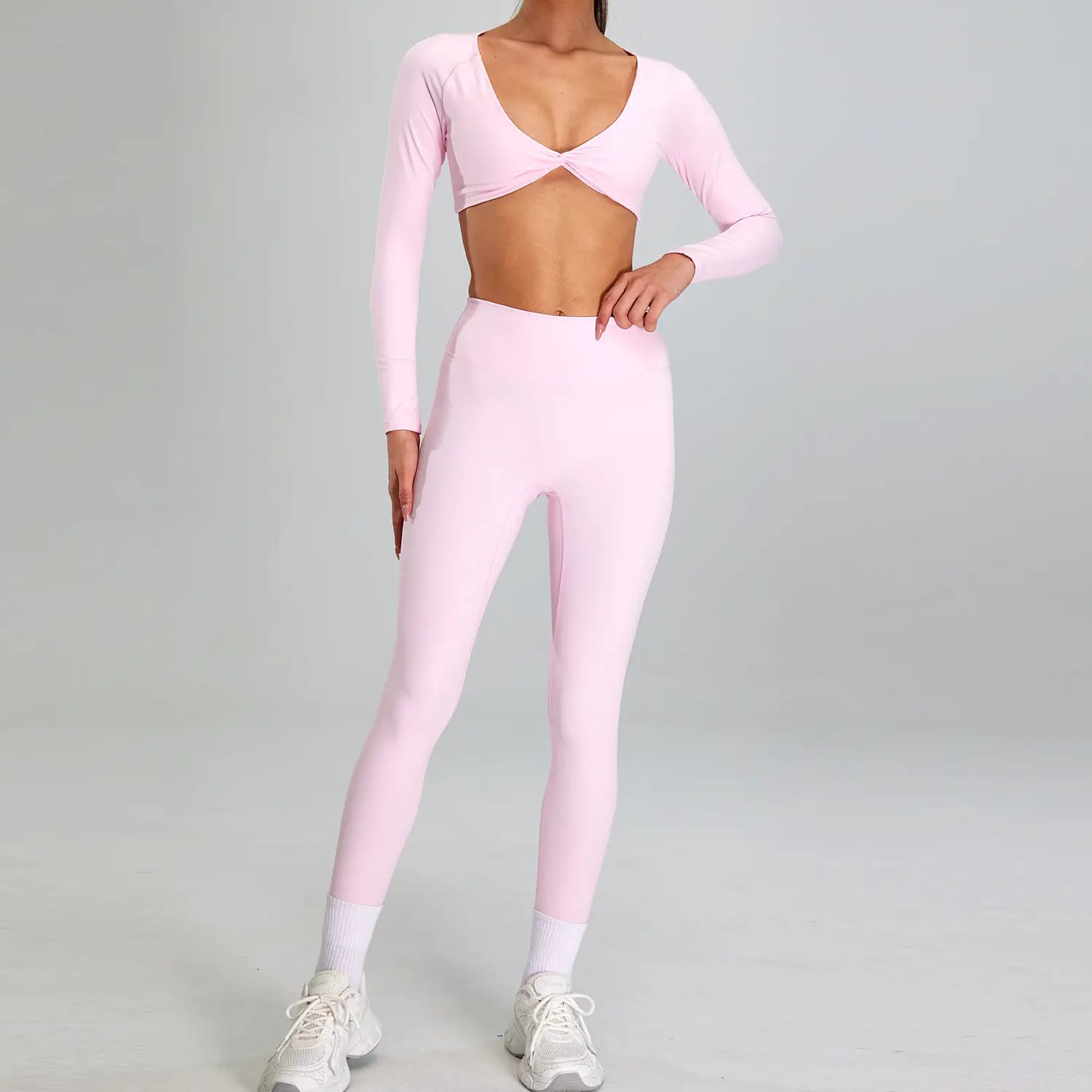 A soft pink form-fitting two-piece outdoor running nude sports suit featuring long sleeves and high-waisted leggings designed for outdoor running.
