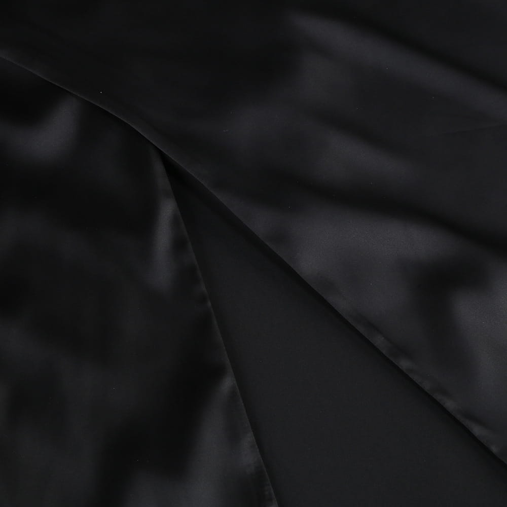 black satin fabric with a smooth glossy finish and subtle sheen on a one-shoulder slit mop black dress two-piece set featuring set sexy lacing details