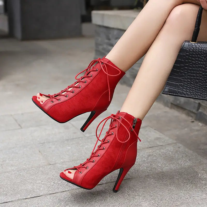 Vibrant red suede lace-up ankle boots with peep toe frosted design and black stiletto heels as frosted casual shoes.