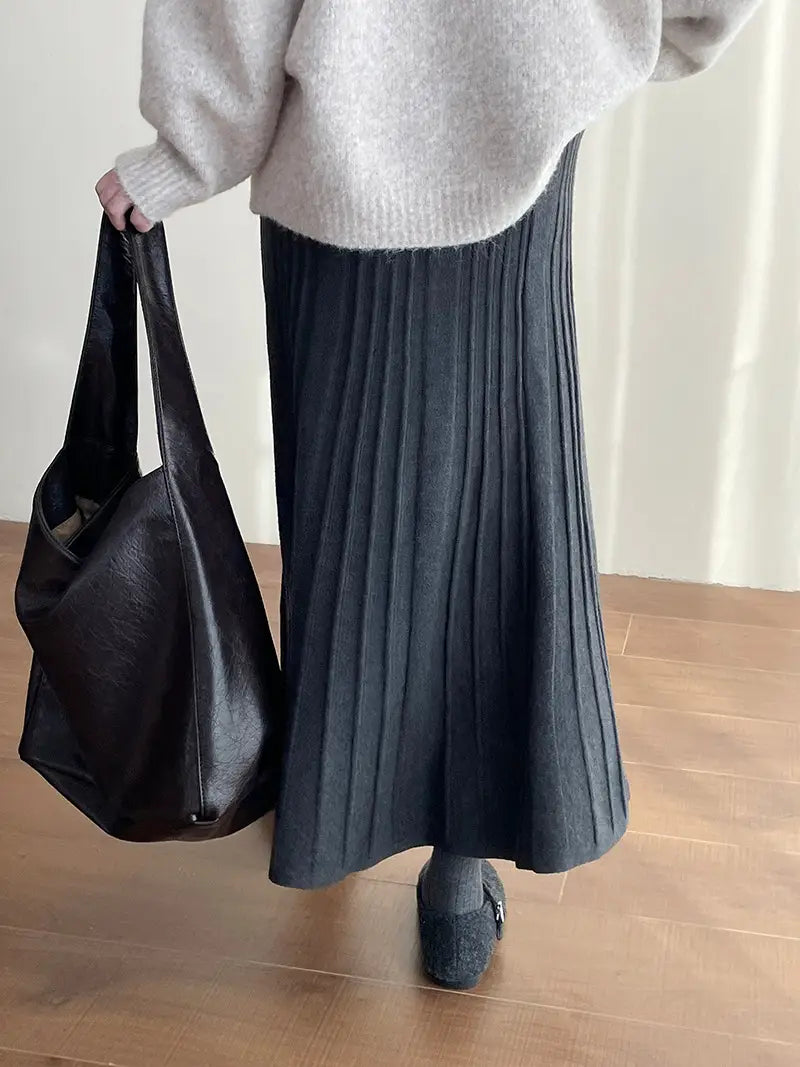 black pleated midi skirt made of soft textured fabric with subtle vertical ridges featuring a korean elastic waist knitted design.