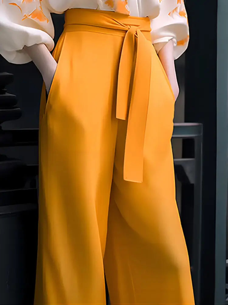 vibrant mustard-yellow high-waisted wide-leg trousers with a matching self-tie belt paired with a floral silk slimming wear flab hiding shirt set