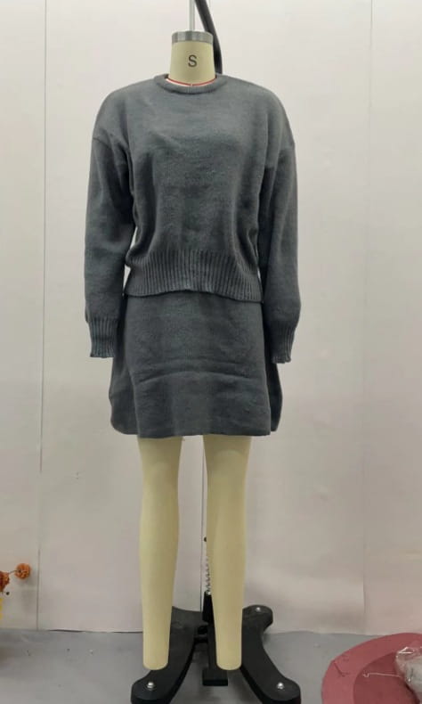 gray knit sweater dress with ribbed cuffs and hemline displayed on a mannequin as part of long sleeve sweater skirt sets pieces knit casual collection.