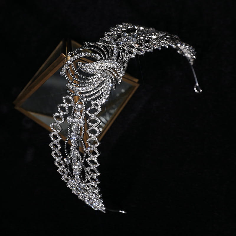 a sparkling silver rhinestone crown luxury bridal headdress featuring intricate crystal embellishments and a flowing feather-like phoenix motif design