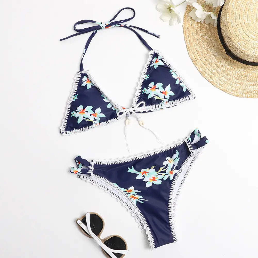 Navy blue hand-crocheted floral bikini set with shell design and white frayed trim displayed in a bikini image.