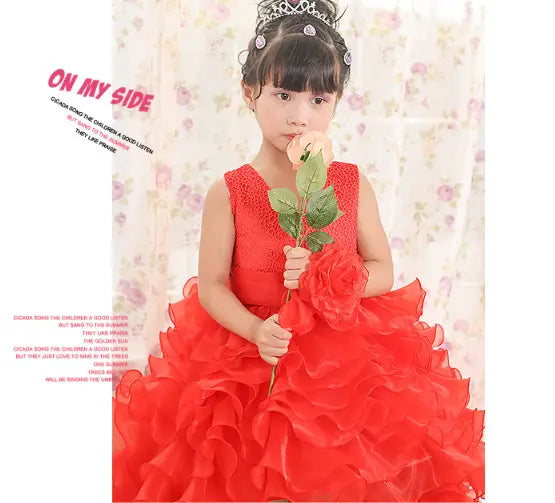A young girl wears a vibrant fuchsia sleeveless lace dress with voluminous layered ruffles designed as a dress flower girl or flower girl tuxedo.