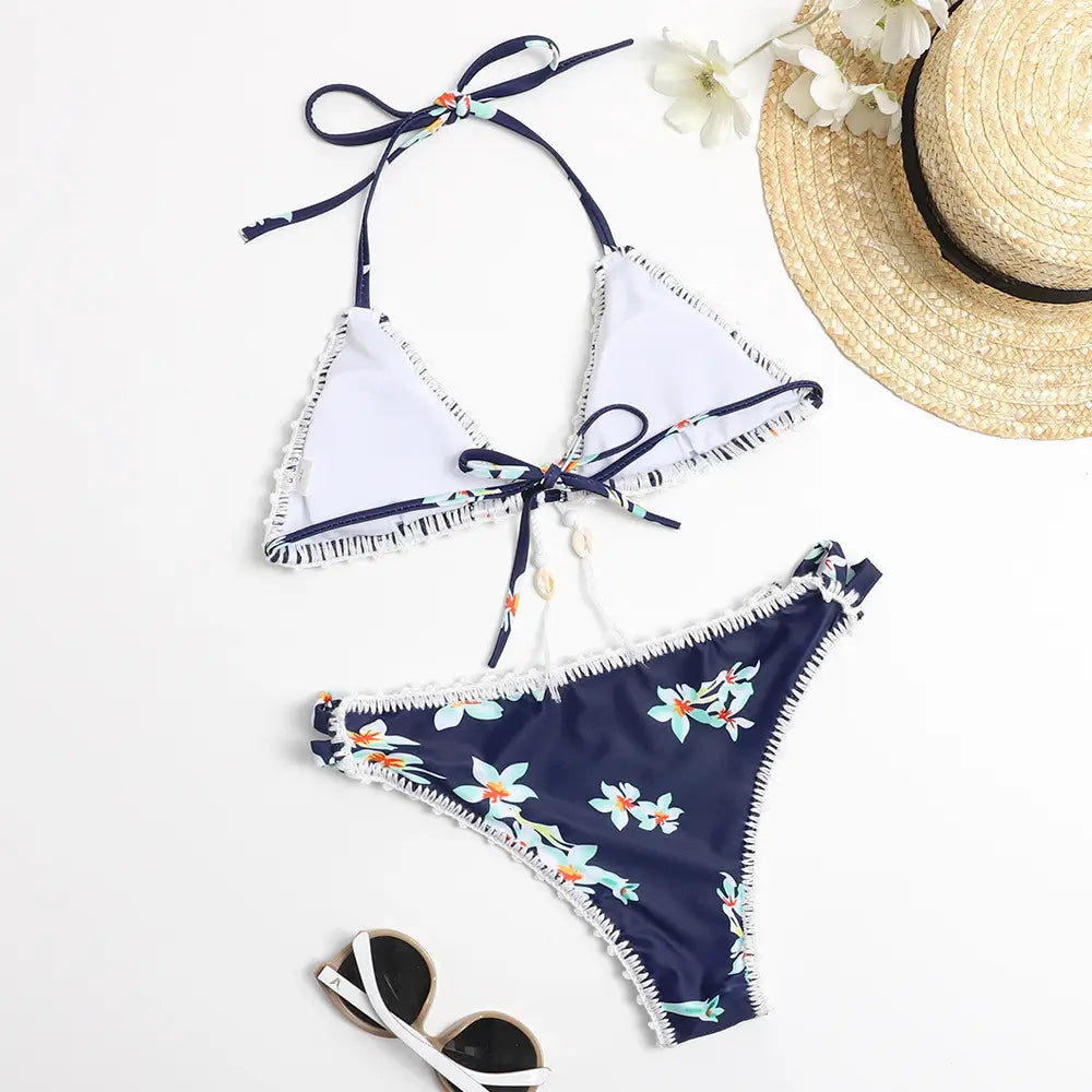 Navy blue hand-crocheted floral bikini with white frayed trim and adjustable ties showcasing a shell design.