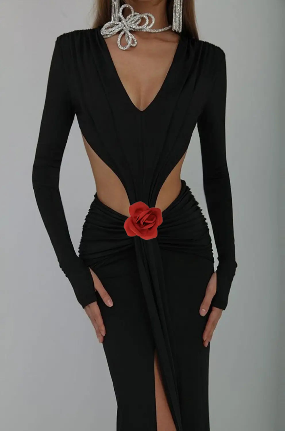 black v-neck backless long sleeves skirt waist gown featuring a long black dress with deep v-neckline, side cutouts, backless design, long sleeves skirt waist, and a red fabric rose accent at the waist