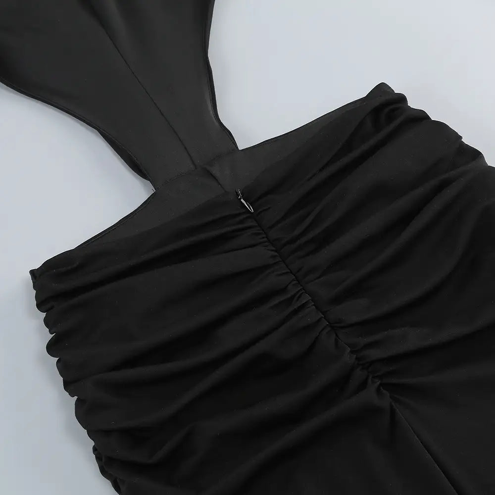 Black ruched halter top with a sleek satin-like finish paired with a black backless long sleeves skirt waist gown.