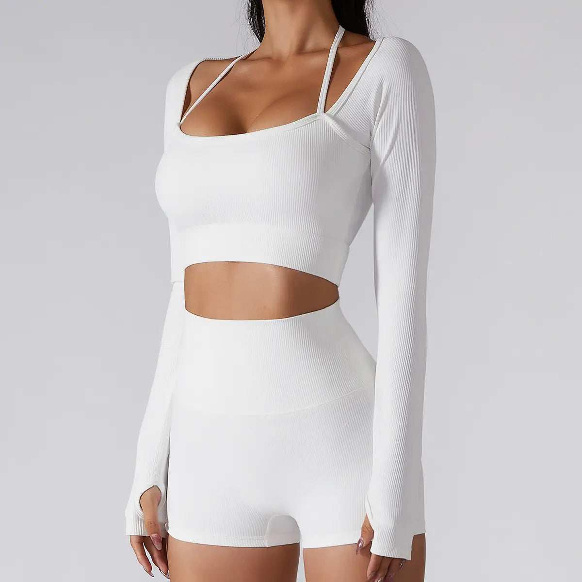 White ribbed long sleeve crop top with thin straps and side cutouts featuring chest pad slim fit for yoga and activewear.