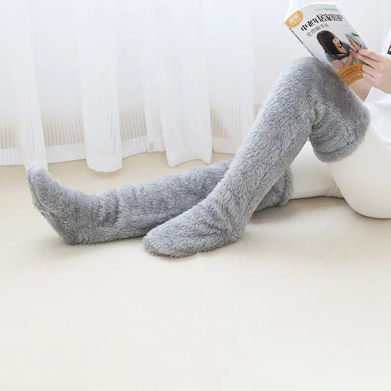gray plush fuzzy long socks with soft fuzzy texture covering over-the-knee legs featuring tan paw print design