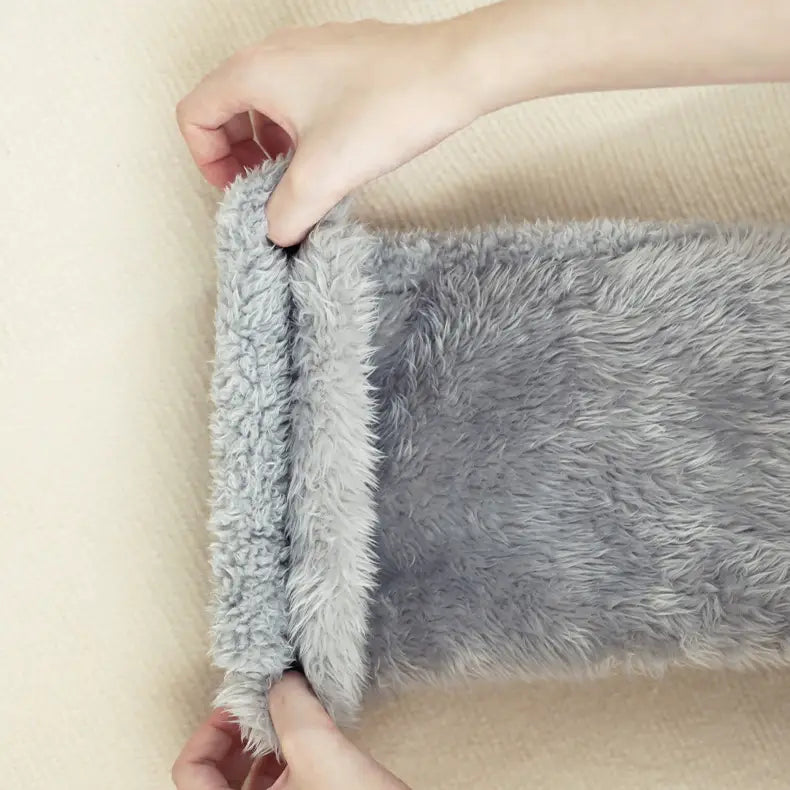 soft gray plush fleece-lined sleeve of tan paw print fuzzy long socks providing warmth and comfort.