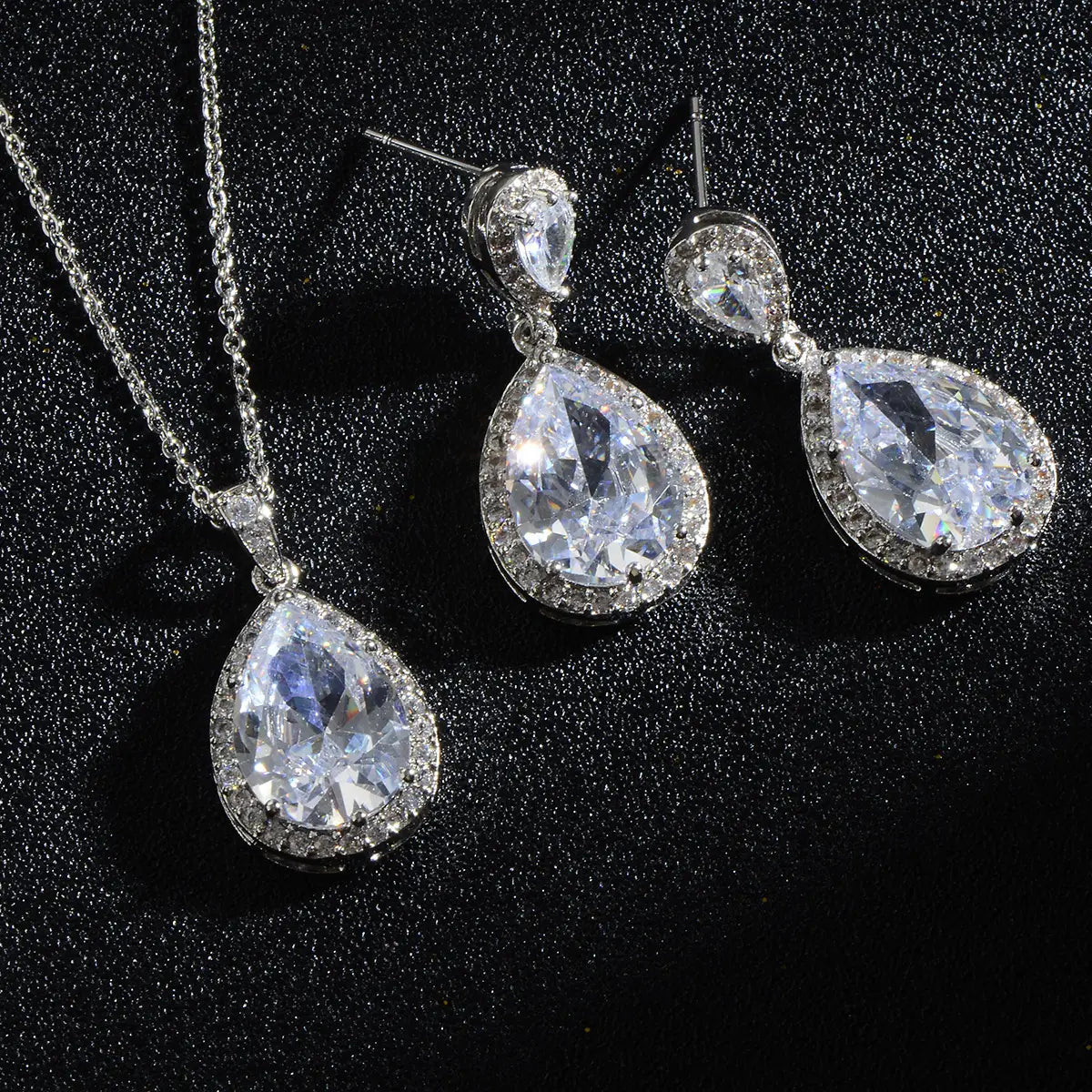 Elegant silver-toned teardrop pendant necklace and matching earrings featuring a bright big zircon central crystal surrounded by smaller pave-set stones in the bright big zircon water drops jewelry set.