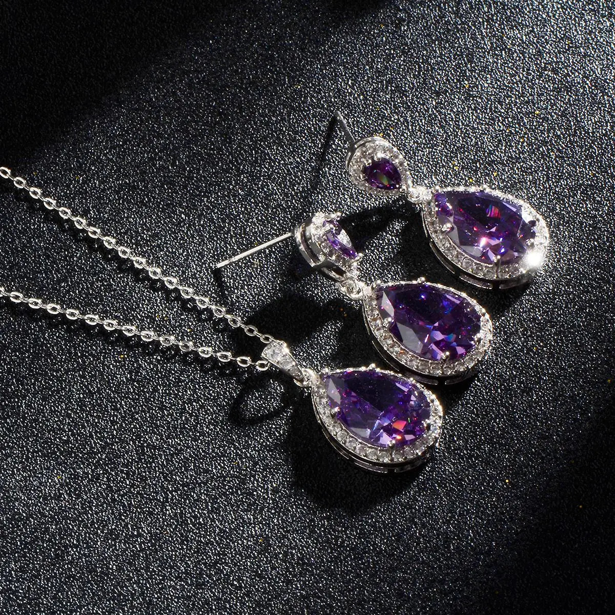 Elegant silver-toned jewelry set featuring bright big zircon teardrop-shaped purple amethyst stones surrounded by sparkling clear crystals in the big zircon water drops style.
