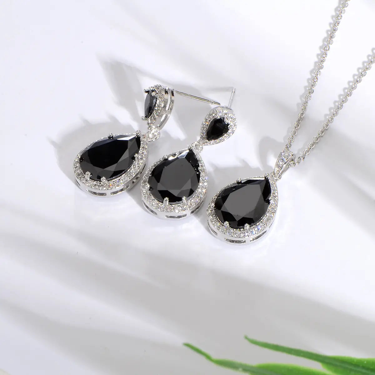 elegant black teardrop pendant necklace and matching earrings set featuring a silver-toned metal frame encrusted with sparkling clear stones around each bright big zircon water drops gemstone.