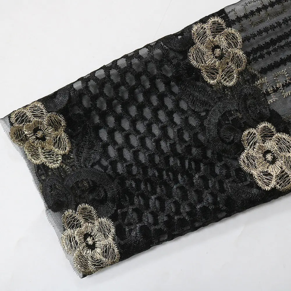 black lace fabric with intricate floral embroidery in metallic gold thread featured on the vest dress kraft tan abaya