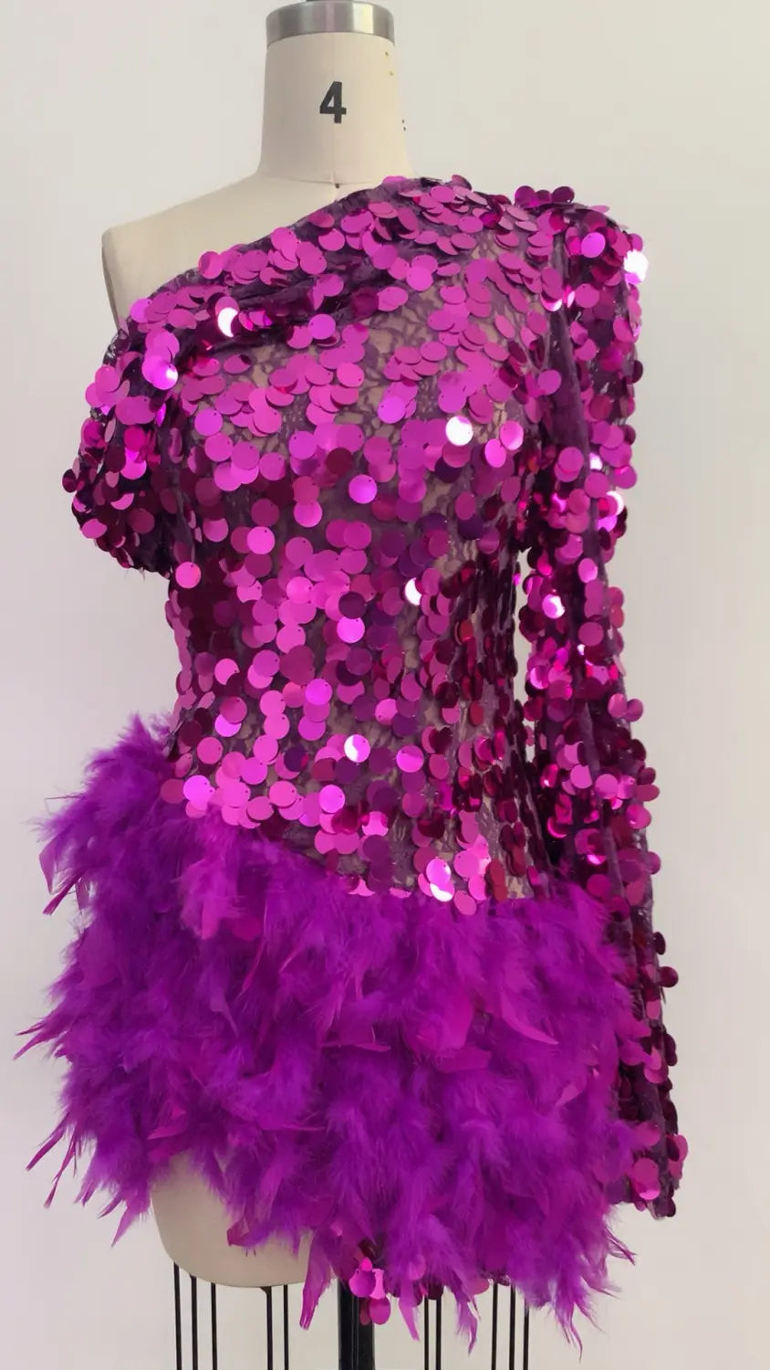 A purple sequined feather sleeve short dress featuring a vibrant magenta one-shoulder top with shimmering circular sequins and a soft purple feathered skirt.
