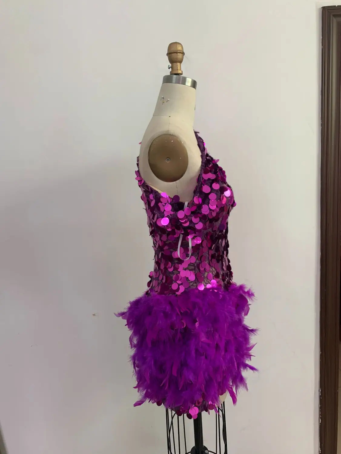 A vibrant purple sequined feather sleeve short dress with a sparkling sequined feather skirt displayed on a mannequin.