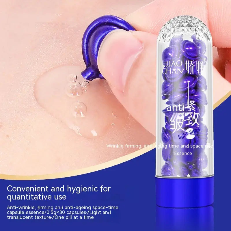 A transparent glass tube with a blue metallic cap and base filled with purple spherical capsules of blue big chicken leg anti-wrinkle essence.