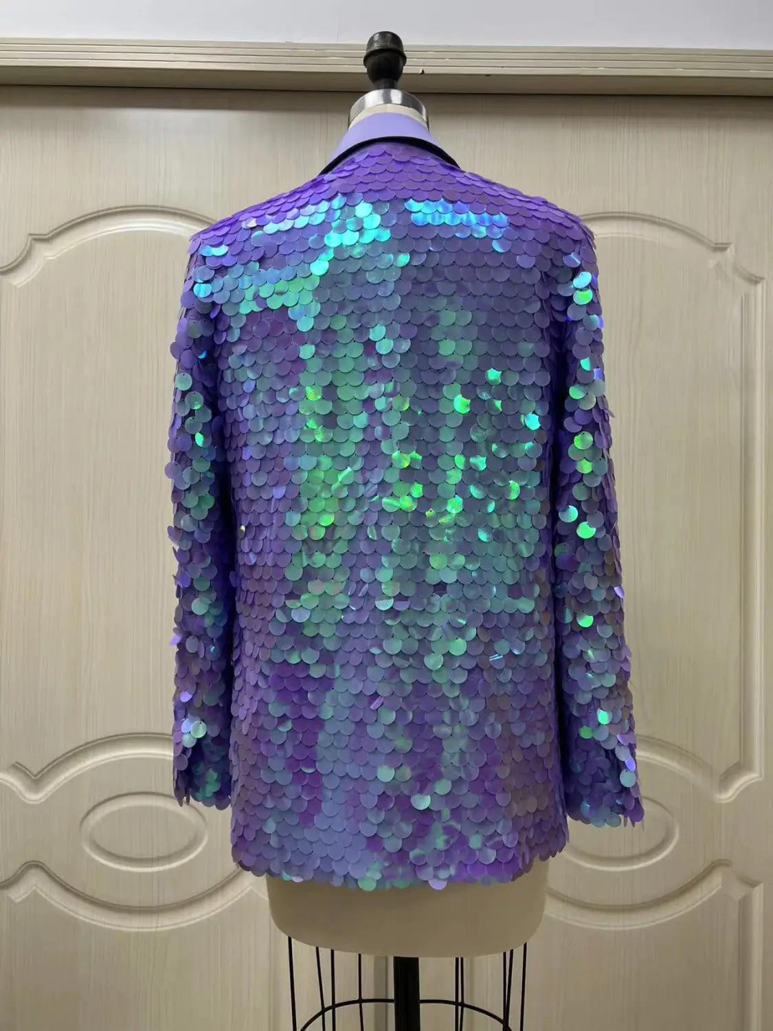 A shimmering purple and teal loose sequin fashion suit blazer with a sleek, form-fitting design ideal for a high dinner party.