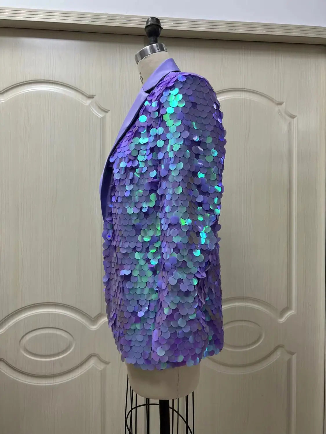 Lavender sequin fashion suit blazer in shimmering purple with iridescent teal and blue highlights displayed on a mannequin for high dinner party occasions.