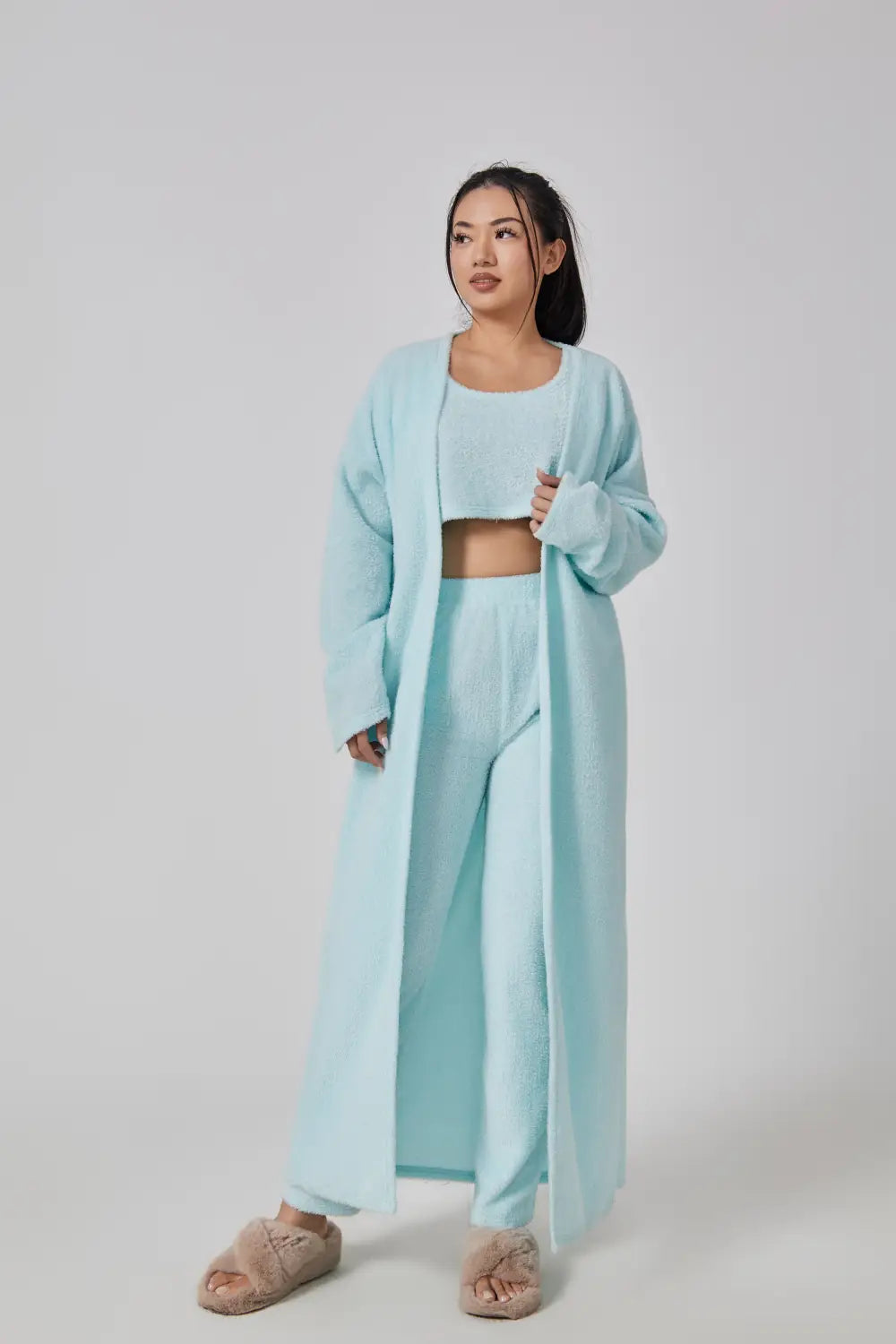 a soft light blue knit three-piece lounge set featuring a long cardigan crop top and wide-leg pants designed for cozy pajama set comfort
