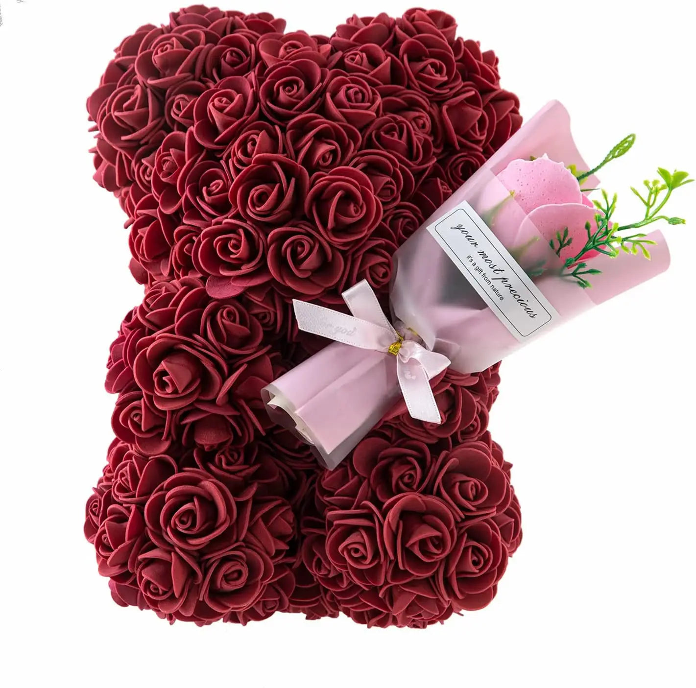 a plush rose bear crafted from deep red artificial roses holding a small bouquet of pink flowers wrapped in sheer paper with a white ribbon, presented as an eternal flower gift box