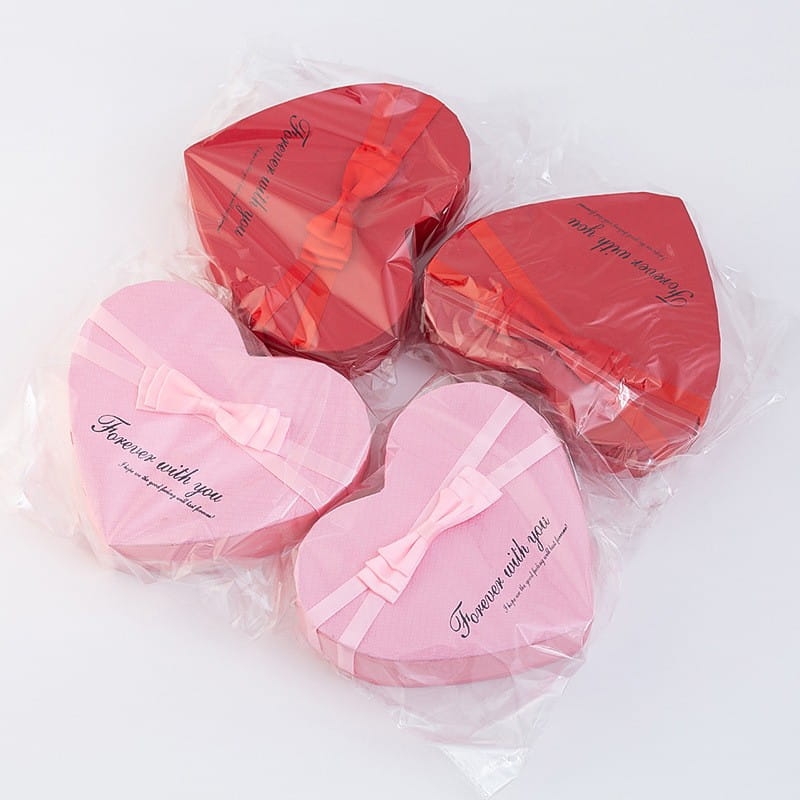 Rose red and pink heart-shaped gift boxes with satin ribbon bows designed as a mother’s day gift box.