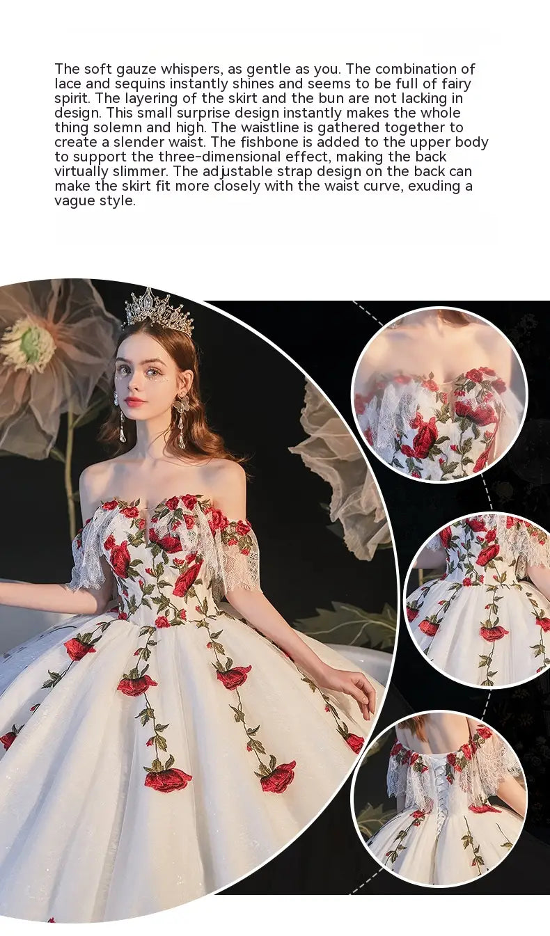 A white off-the-shoulder wedding dress featuring intricate red rose embroidery, delicate lace detailing, and a fitted bodice with corset-style temperament bride bra lacing.