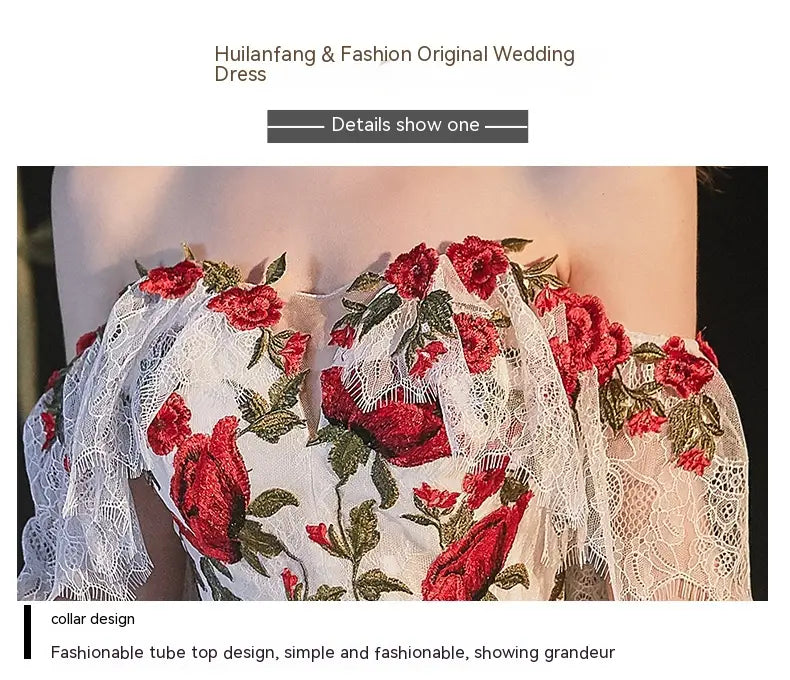 A white lace wedding dress with intricate red rose embroidery and green leaf accents featuring a fashionable temperament bride bra tube top design.