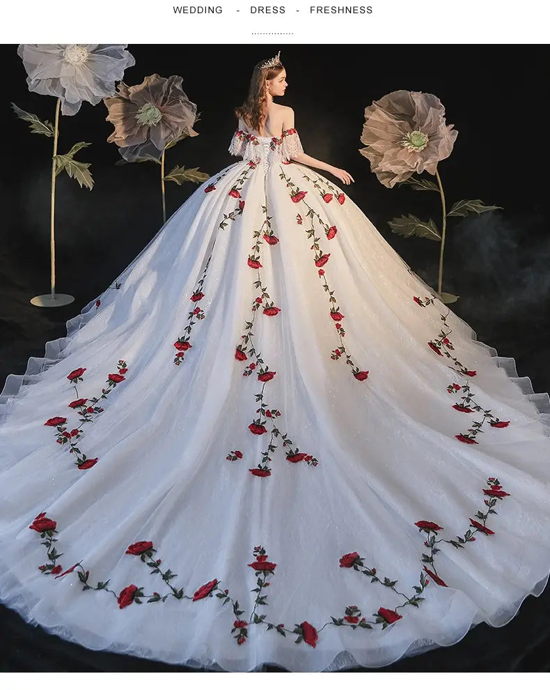 A flowing white wedding dress featuring intricate red rose embroidery along the skirt and off-the-shoulder temperament bride bra bodice ideal for a bride bra trailing look.