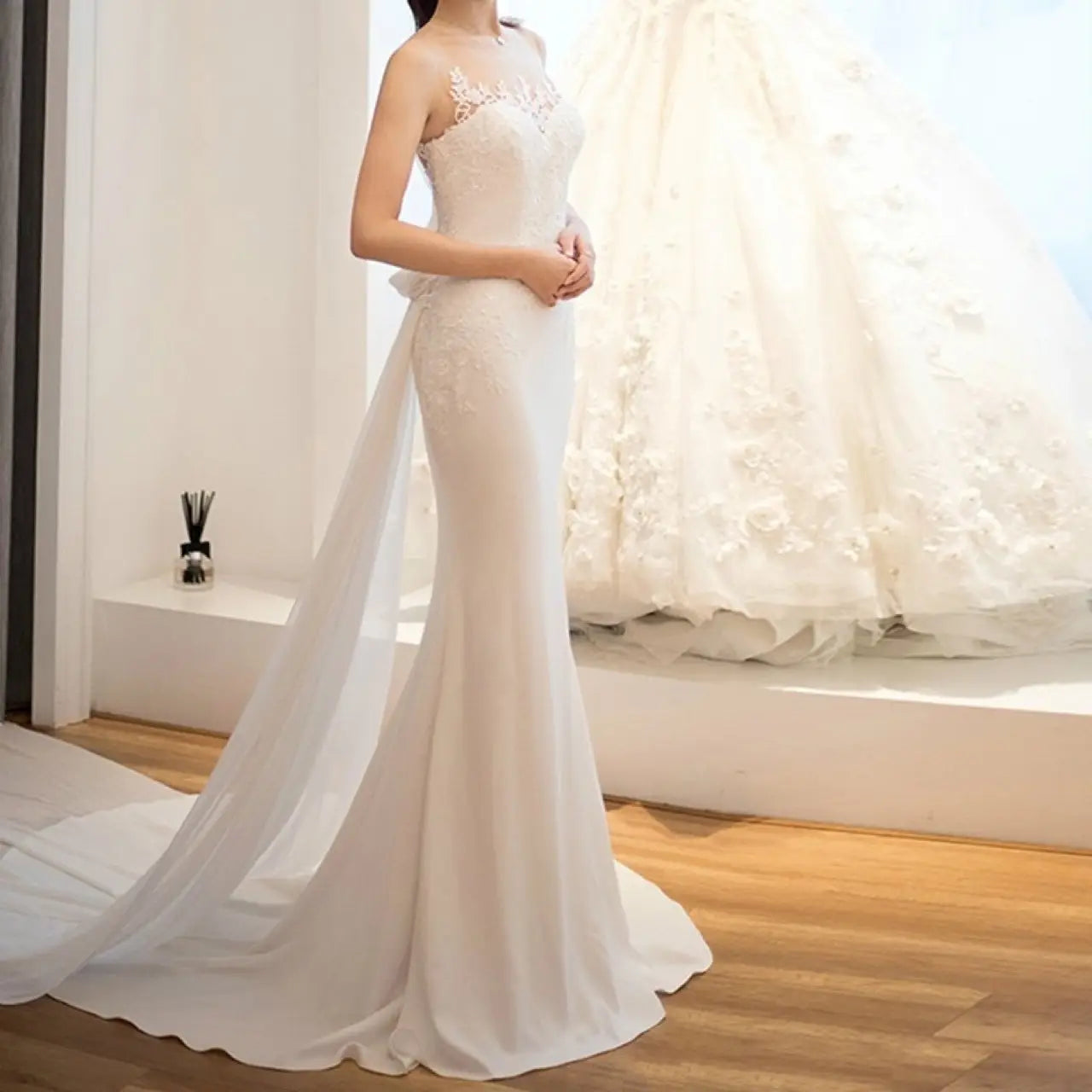 A white lace mermaid super fairy light wedding dress featuring delicate lace detailing and a flowing train for an elegant light wedding dress look.