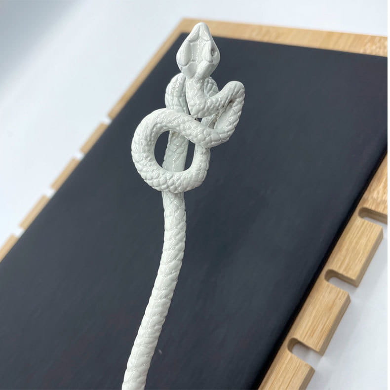 a white knotted rope retro style hairpin featuring an intricately coiled snake shape with a textured rope-like body and detailed scales