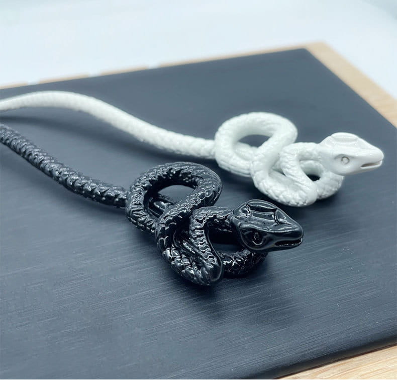 black and white snake-shaped pendant necklaces with textured coiled designs complement retro style hairpin accessories in white knotted rope.
