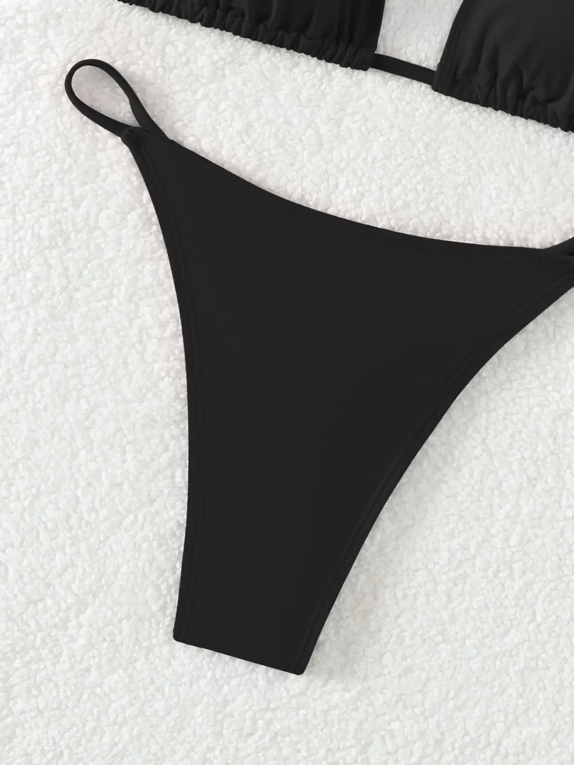 black sleek and minimalist thong bikini bottom with smooth stretchy fabric finish featured as part of a red triangle cup halter bikini swimsuit for swimwear collections