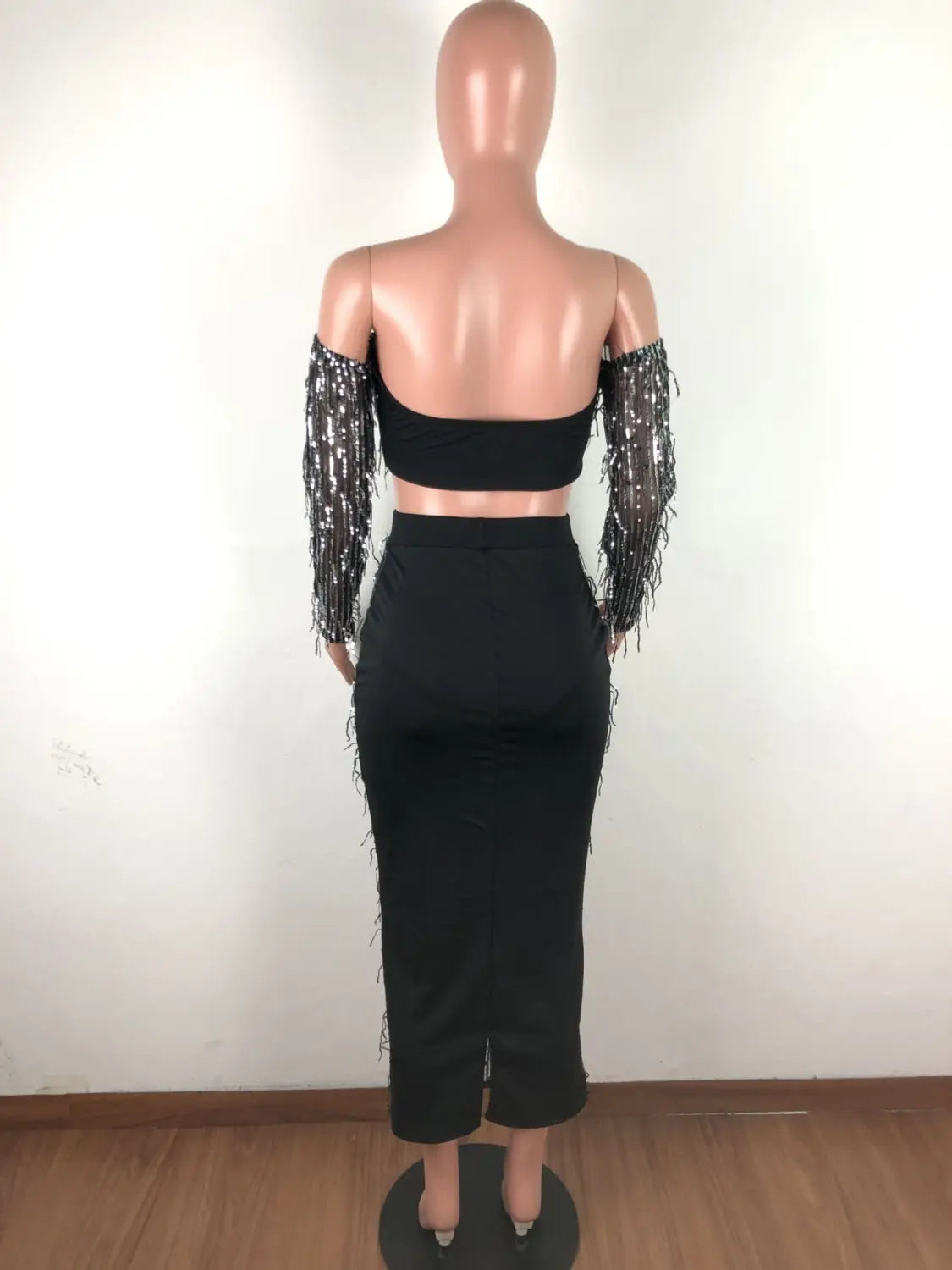 black mesh sequins tassel two piece set featuring a black off-the-shoulder crop top with long shimmering mesh sequins sleeves and a matching high-waisted pencil skirt with fringe detailing for a fashion sexy look.