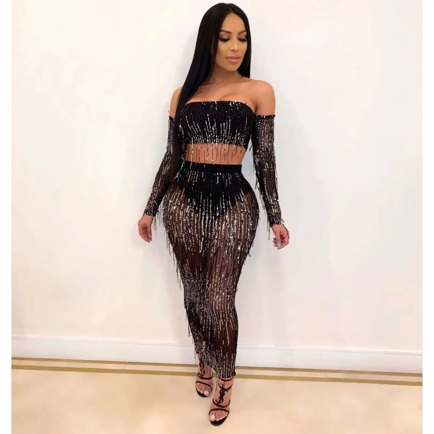 black mesh sequins tassel two piece set featuring a black off-the-shoulder crop top and matching skirt with shimmering mesh sequins and fringe detailing for a fashion sexy look