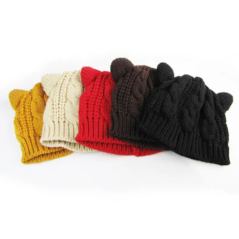 a collection of cute knitted cat ear beanies made 3d with a cable-knit pattern in mustard cream red brown and black colors