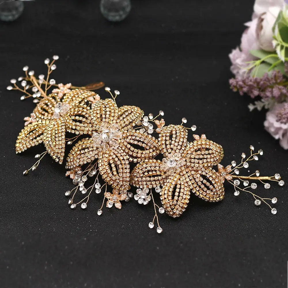 A delicate gold-toned bridal flower rhinestone hair accessory featuring intricate floral designs adorned with sparkling rhinestones and tiny crystal beads for weddings.