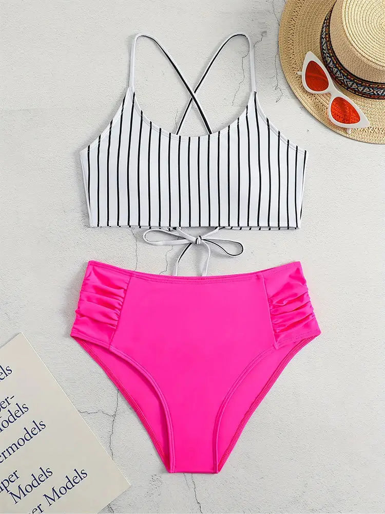 Bright pink high-waisted bikini bottom with ruched side panels featured in a striped bikini split swimsuit for women.