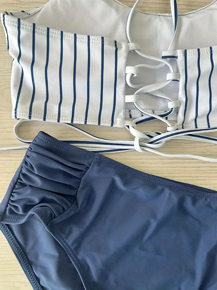 white and navy blue striped bikini top with lace-up front detail in a pink striped bikini split swimsuit for women