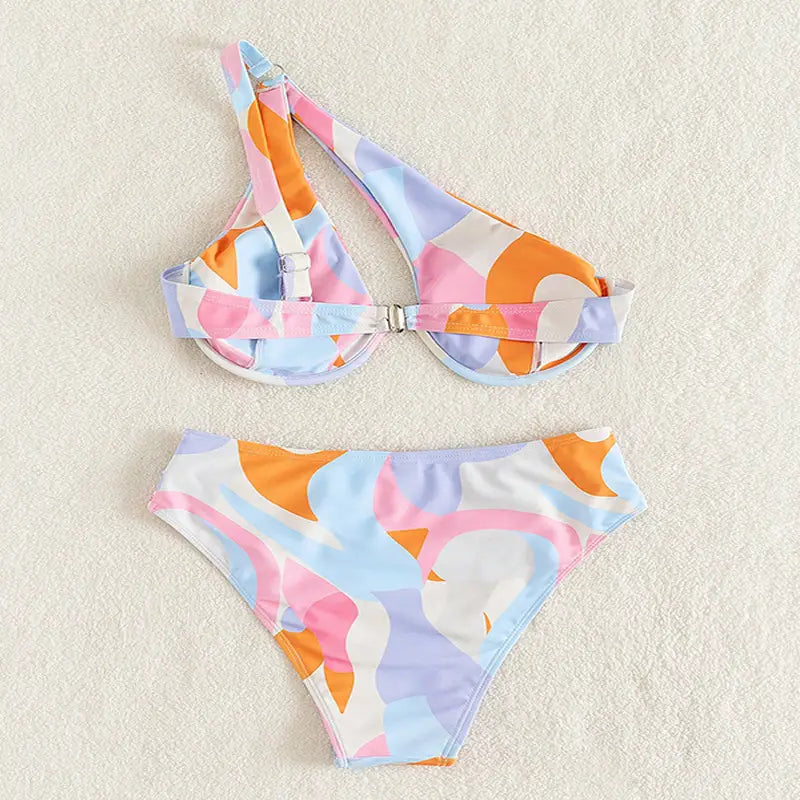 pastel abstract bikini print fashion split swimsuit featuring a pastel-colored bikini set with abstract geometric patterns in soft pink blue and orange on a white base