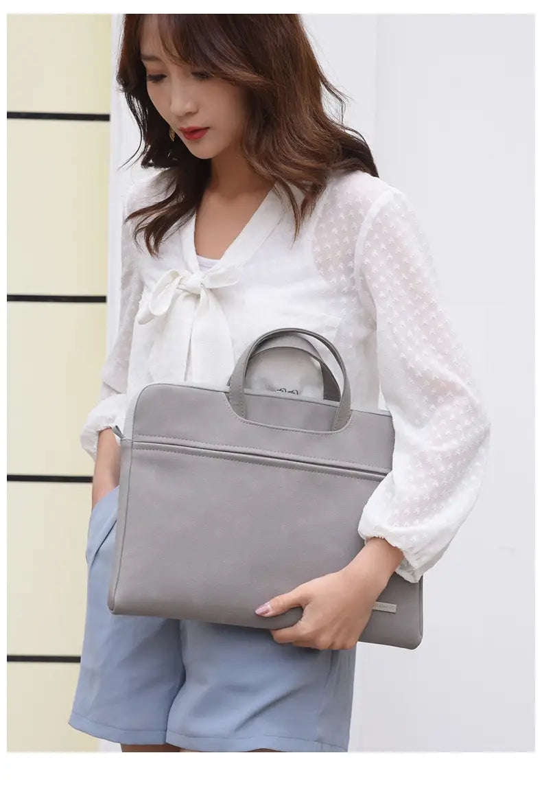 gray leather women laptop bag with structured design and top handle shown alongside pink pu leather women laptop bag with pouch